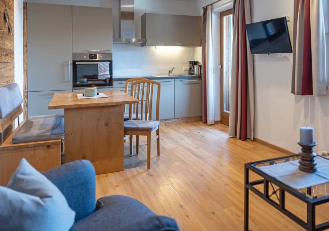 A cozy kitchen-living area with wooden furniture and modern appliances