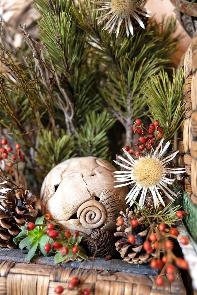Decorative arrangement with pinecones, red berries, flowers, and a spiral design element