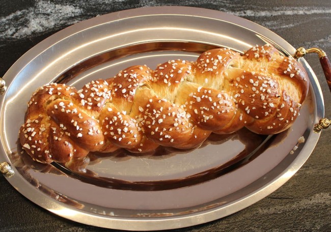 Braided bread topped with sugar crystals on a silver platter