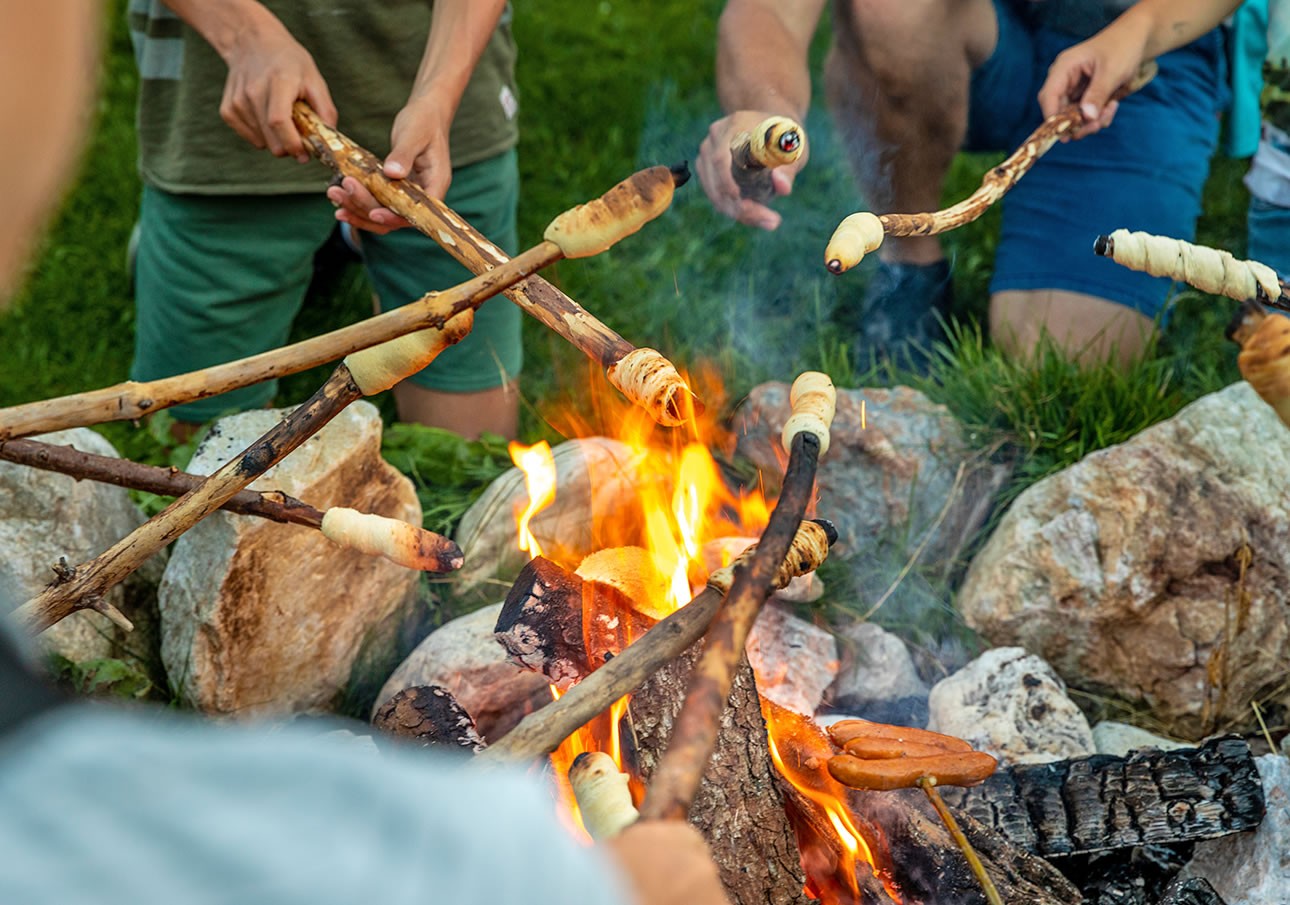 Viele Vorteile für Familien mit der Flachau Sommer Card wie Steckerlbrot und Würstchen grillen